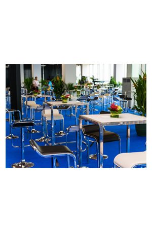 a large conference room with replica lem barstools on a blue carpet