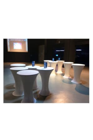 a group of bombo tables with black spandex in a room with a projection screen