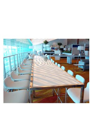 a barcelona long bar table with white chairs in front of it