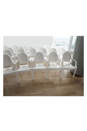 a row of replica louis ghost chairs in an empty room