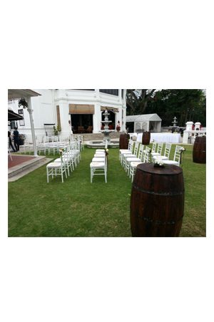a wedding ceremony set up with tiffany chairs and barrels