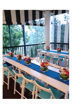 a table set up with blue and classic white folding chair tablecloths