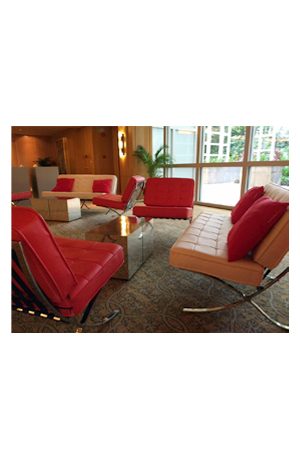 a lobby with red leather chairs and a matty mirrored cube