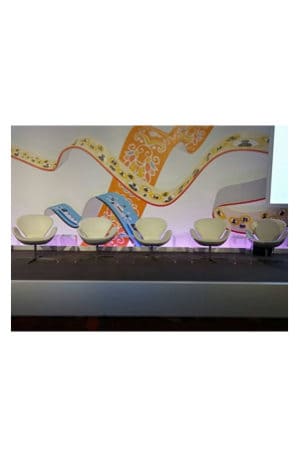 a group of replica muji acrylic side tables in front of a large mural
