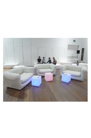 a group of people sitting on illuminated cube 40s in a room