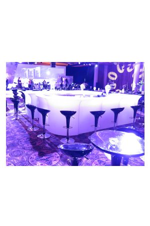 an illuminated corner bar set up with purple lights and stools