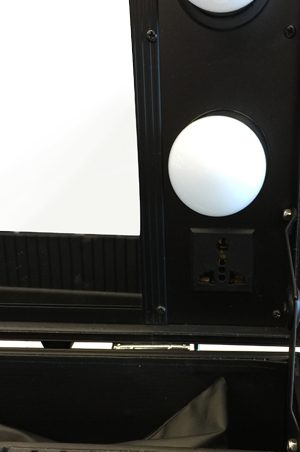 a black dressing table with two lights inside it